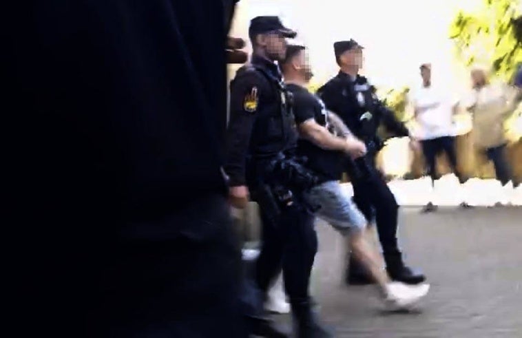 Uno de los detenidos, escoltado por los agentes al furgón de la Policía.