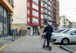 Un vecino se desplaza con un patinete, en Torrelavega.