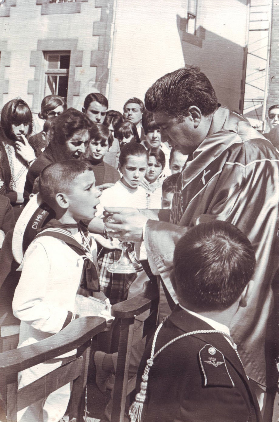 Dando la comunión a los niños del Pesquero.