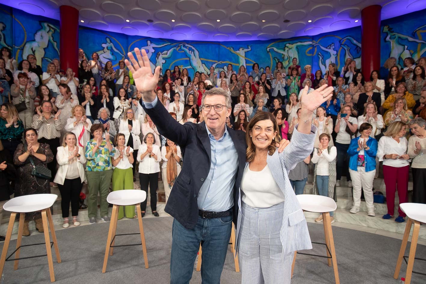 Alberto Núñez Feijóo y María José Sáenz de Buruaga saludan al público durante el acto celebrado en Santander.