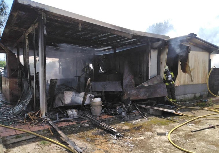 Tras sofocar el incendio, un bombero examina los restos todavía humeantes de la edificación.