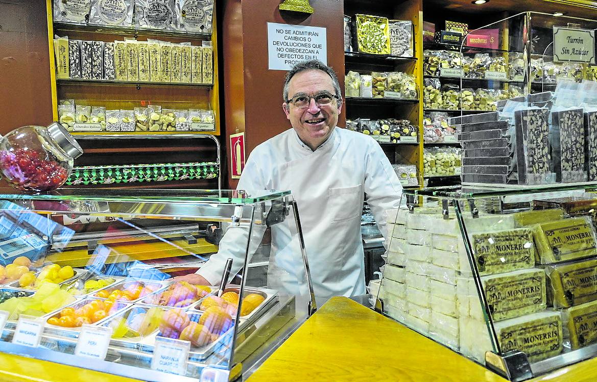 Alfredo Mira, tras el mostrador de Monerris y rodeado de dulces.