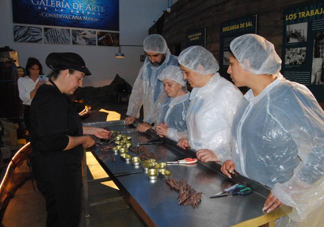 La sobadora Raquel González da instrucciones a los participantes de cómo se filetea la anchoa.