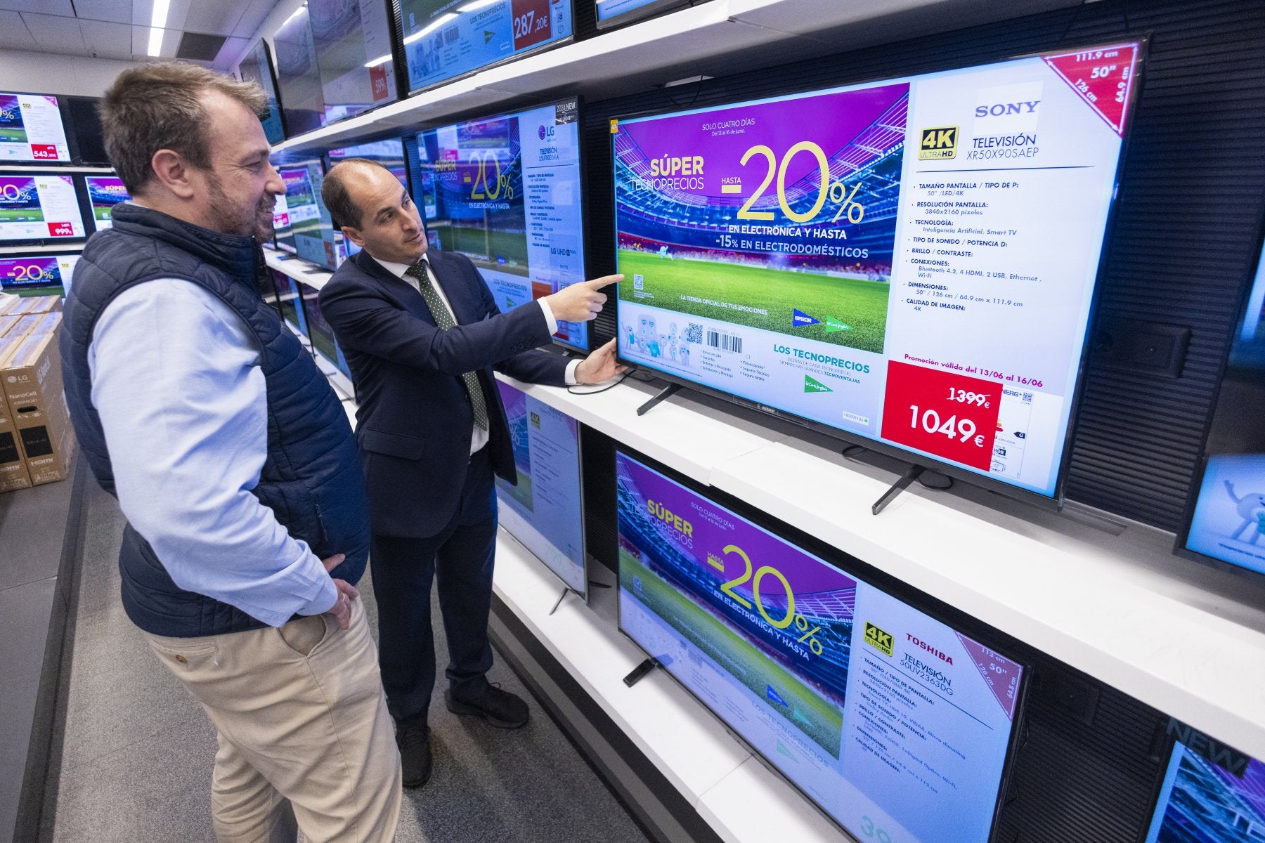 Un vendedor enseña untelevisor a un cliente, en El Corte Inglés.