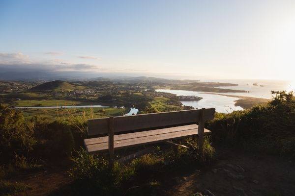 En La Picota, en Liencres, casi al llegar a la cima se encuentra este banco desde el que contemplar la ría de Mogro, el estuario del río Pas, el campo de golf del Abra del Pas, el Parque Natural de las Dunas de Liencres y la Playa de Valdearenas.