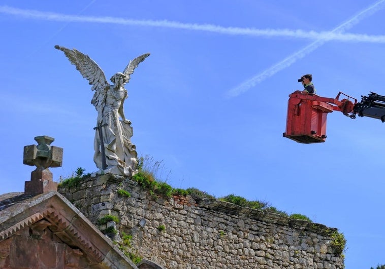 Uno de los técnicos de la empresa encargada de la restauración se acerca en una grúa a la escultura del Ángel Exterminador.