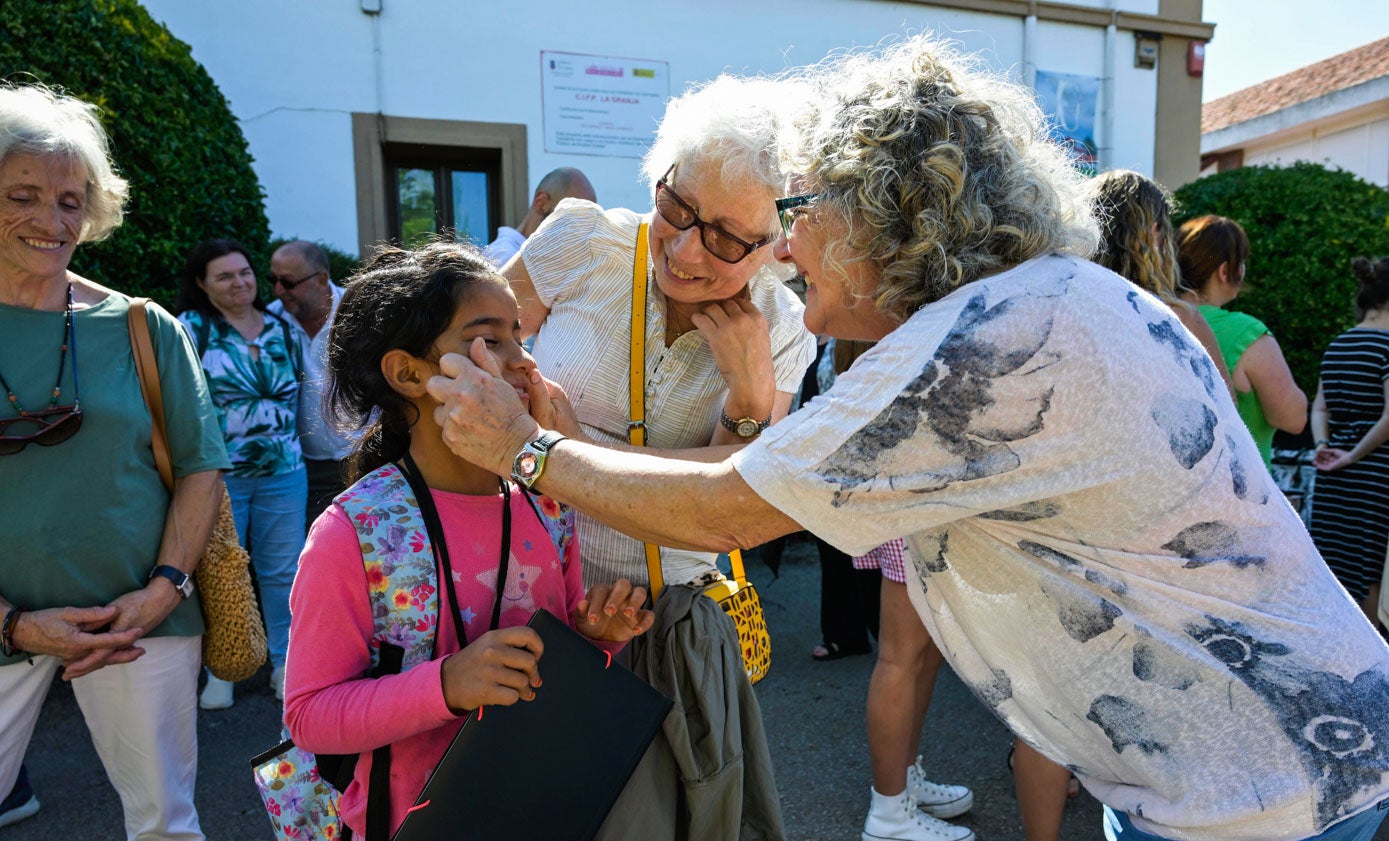 Primeros abrazos y besos entre las familias de acogida y los niños en el Centro Integrado de FP La Granja, en Heras (Medio Cudeyo). 