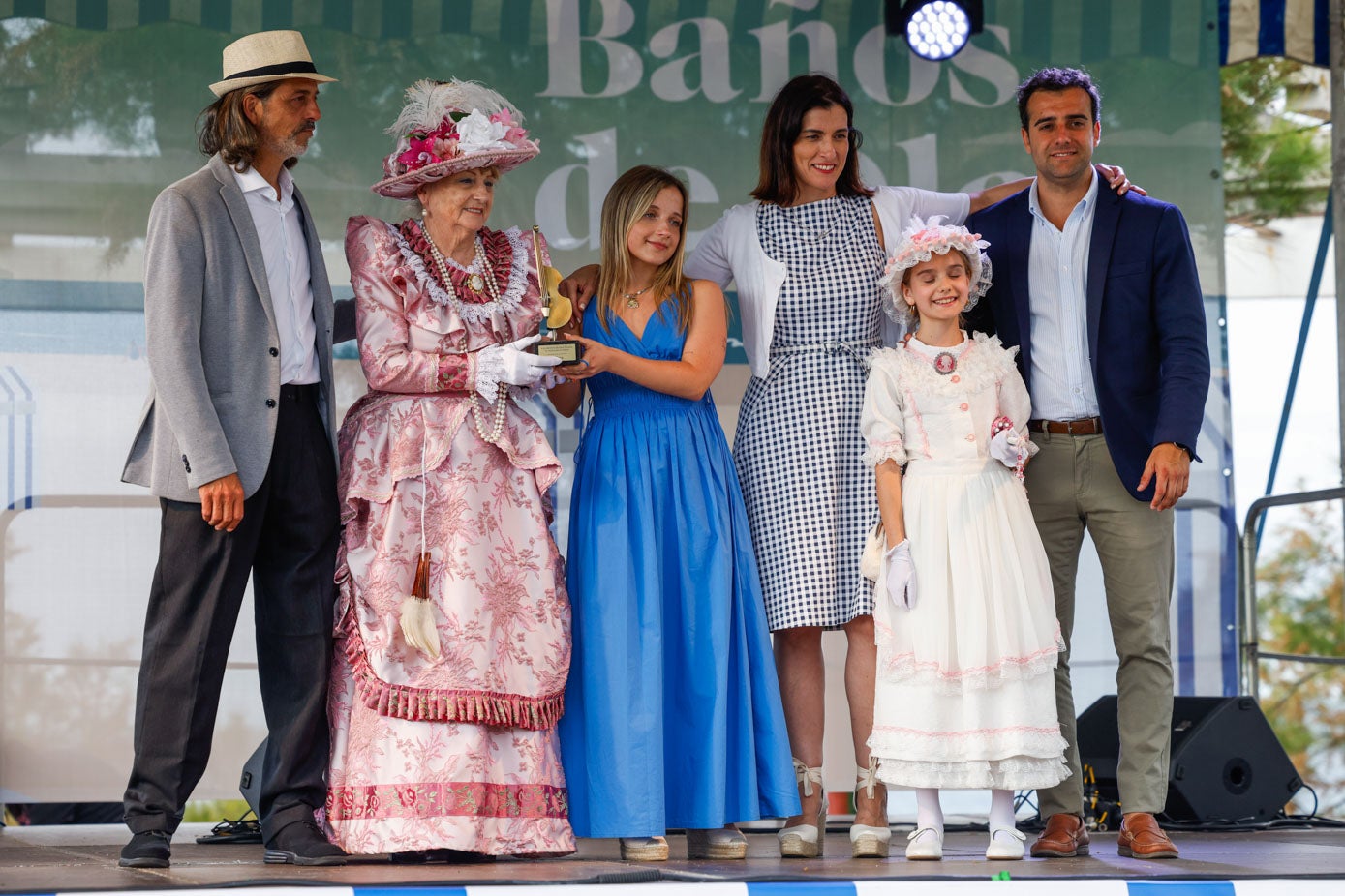 Vera Simons, diseñadora de trajes de época, recoge una escultura en forma de contrabajo en homenaje a su hijo Dani Simons, que falleció en un accidente de moto a principios de mayo. Junto a ella, sus otros hijos, la alcaldesa de Santander, Gema Igual, y el concejal de Turismo, Fran Arias. 