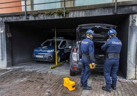 Especialistas de la división científica de la Policía Nacional, en el acceso al garaje incendiado.