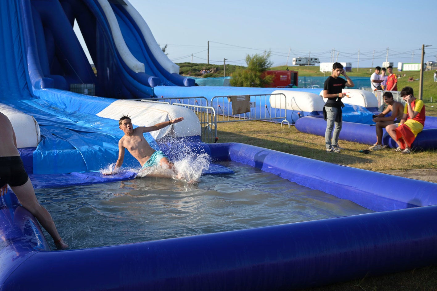 Los jóvenes aprovechando los hinchables acuáticos para refrescarse.