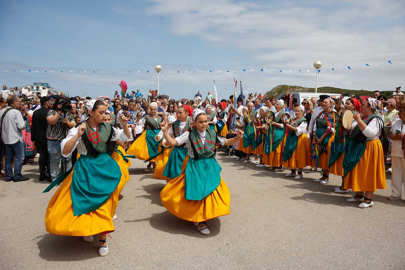 Cientos de personas han seguido con devoción la procesión de la virgen del Carmen en el paseo marítimo de Suances. 