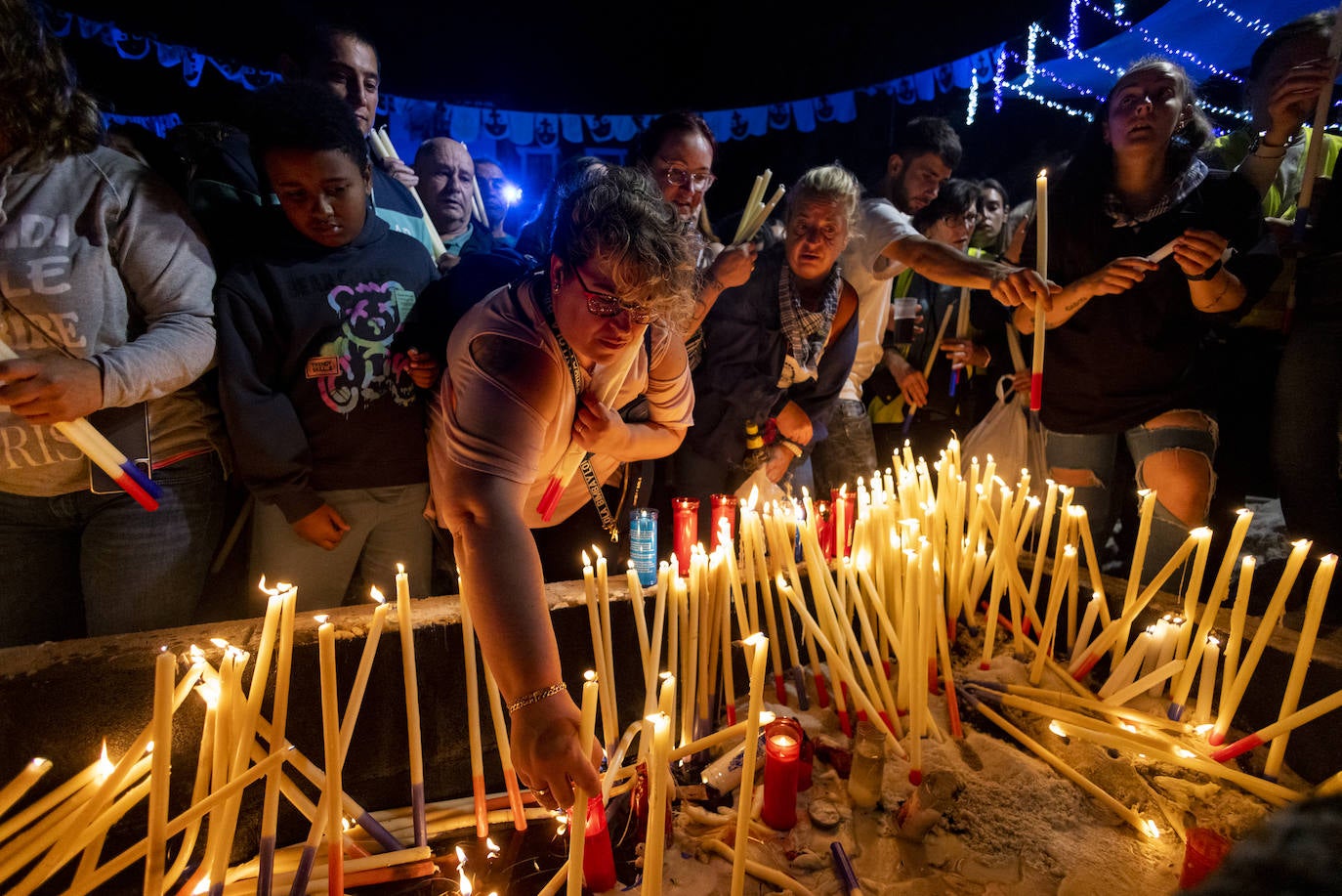 Los asistentes buscan hueco para dejar su vela a la Virgen del Carmen. 