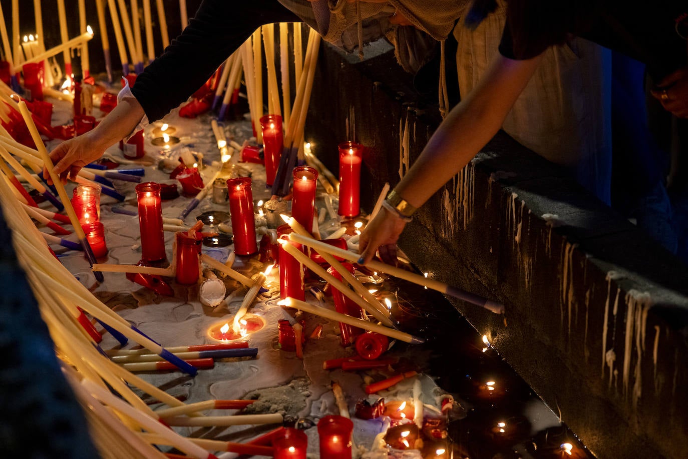 Las velas esconden peticiones personales a la Virgen y mantienen vivo el recuerdo de quienes ya no están.