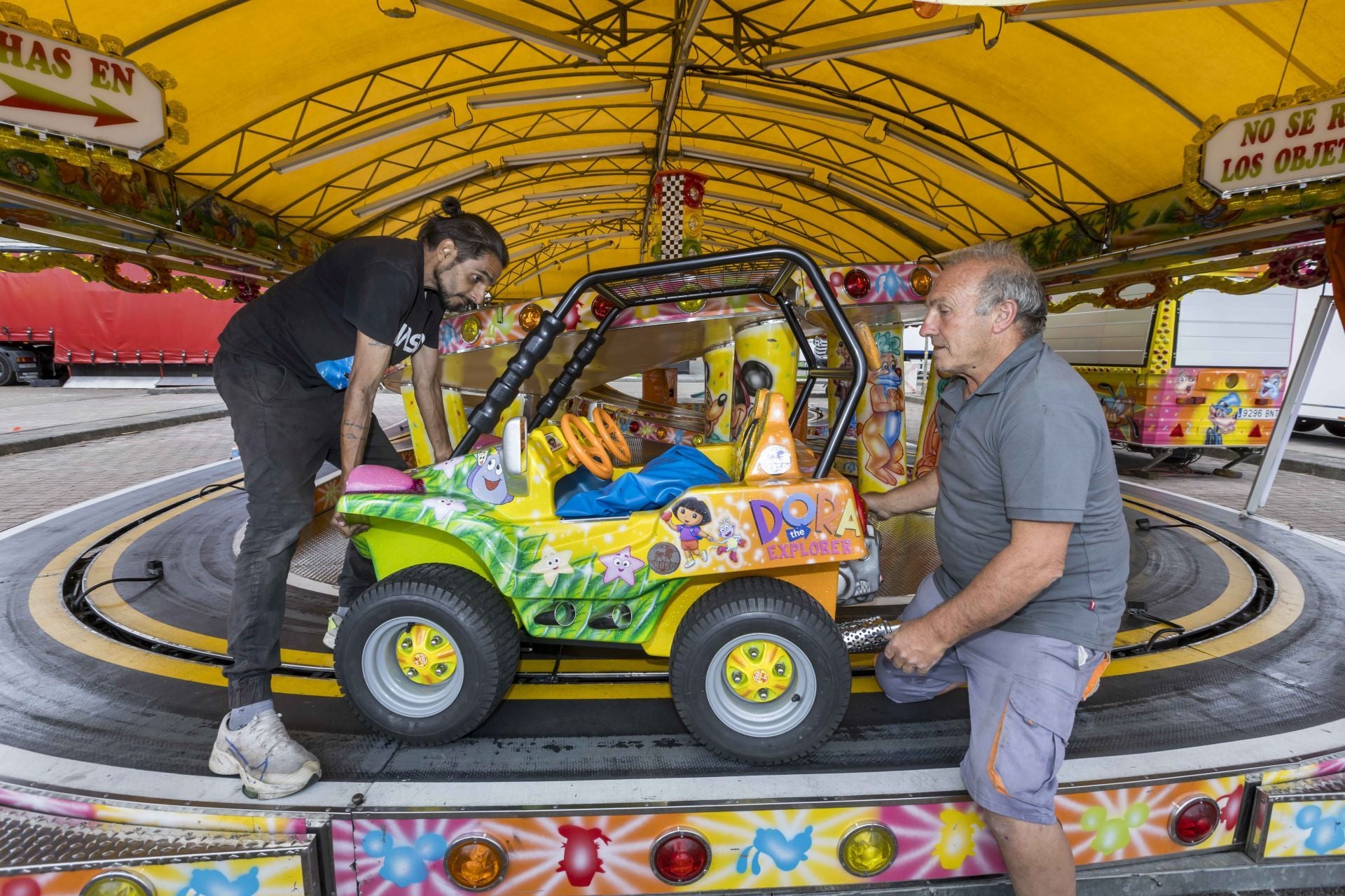 Un trabajador ayuda a José Manuel Nieto a colocar un coche del Scalextric.