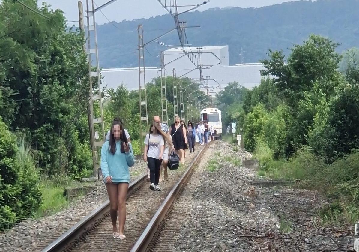 Los afectados por la avería del tren, en dirección a la estación de Heras.