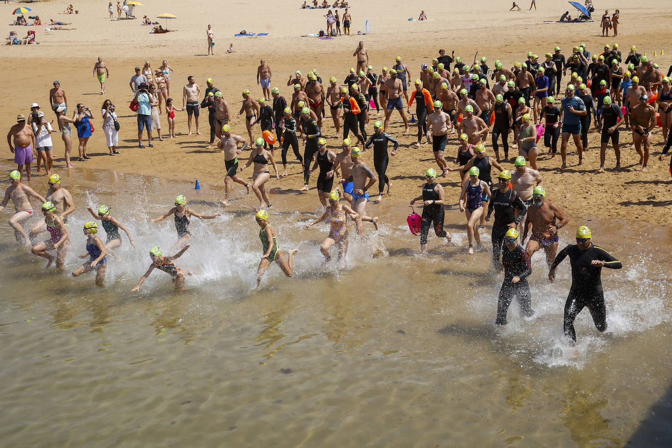 Participantes de la travesía a nado entrando en el agua. 