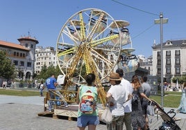 Un grupo de niños disfruta de la noria de la Plaza de Alfonso XIII ante la atenta mirada de sus familiares.