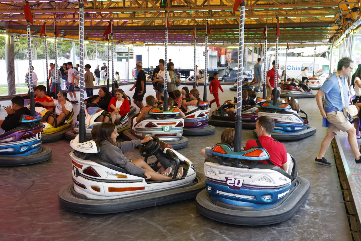 Niños y mayores disfrutando de los coches de choque..