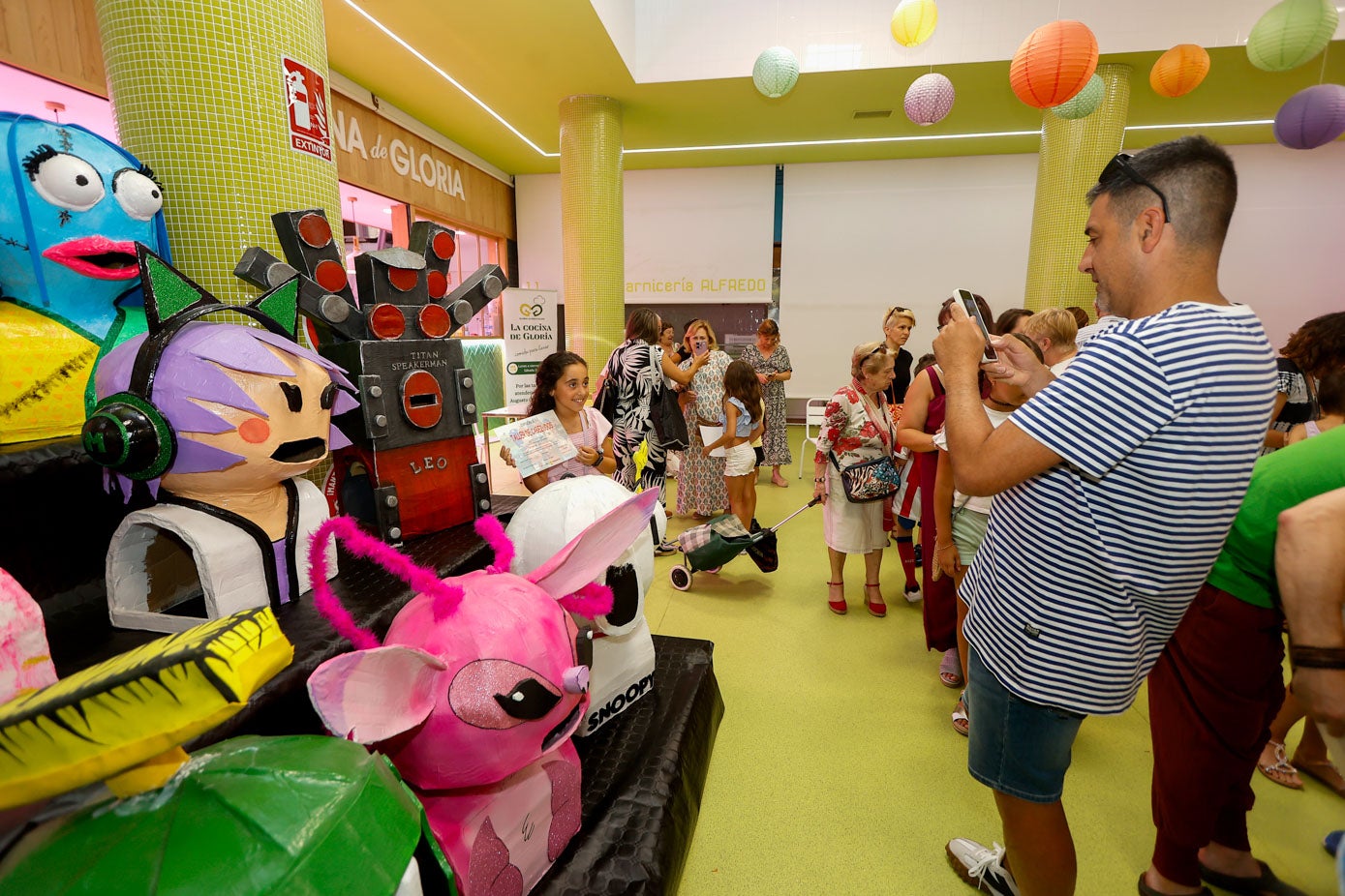 Un padre fotografía a su hija junto a las creaciones. 