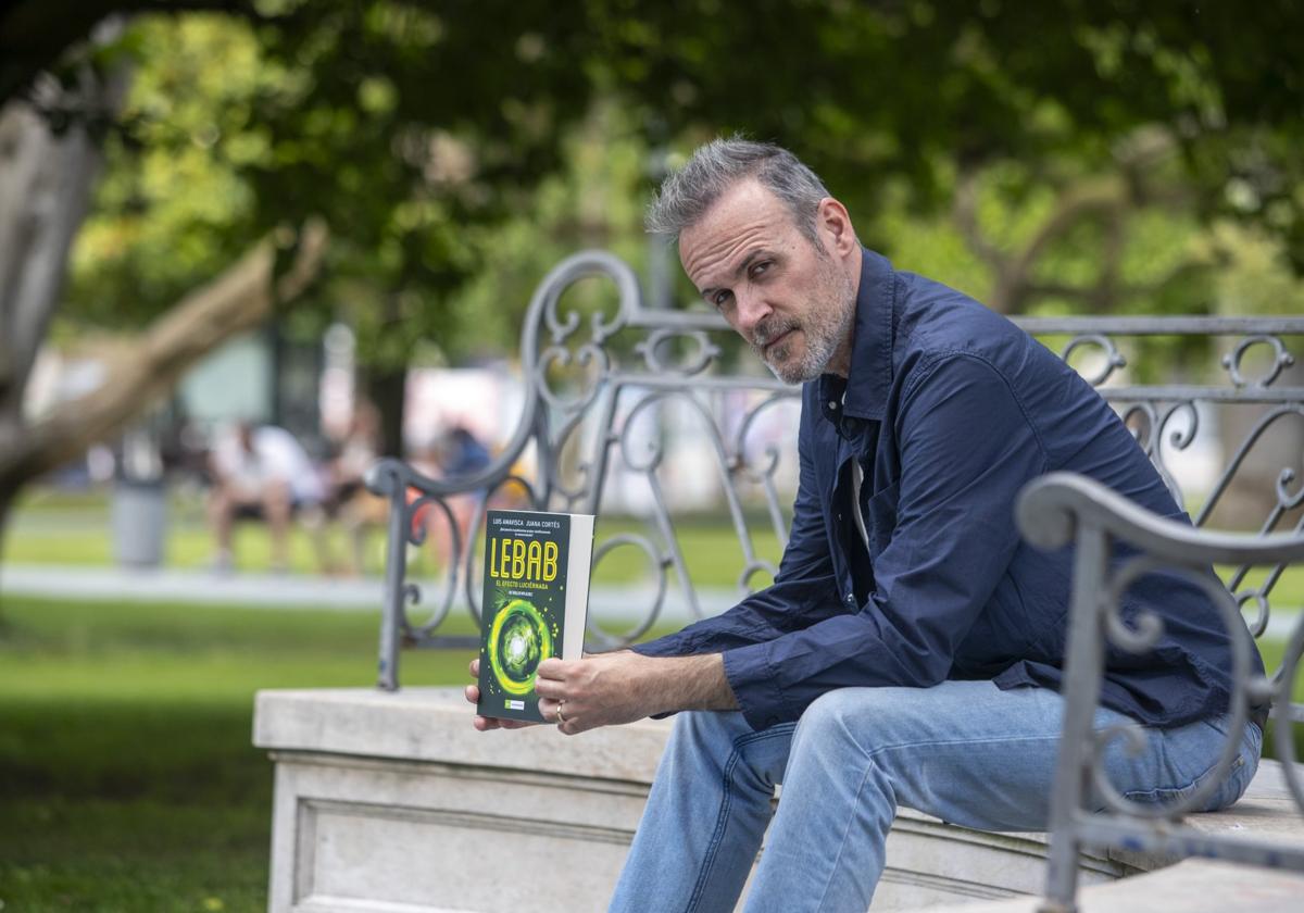 Luis Amavisca en los jardines del Paseo de Pereda (Santander), con su novela.