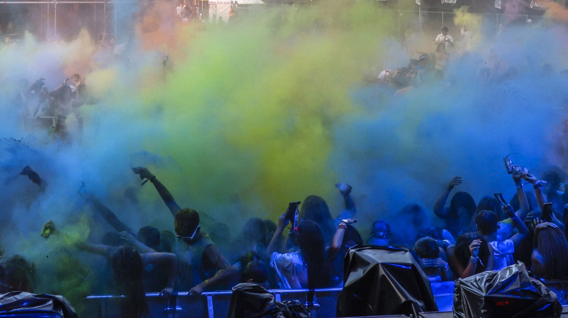 Grupo de jóvenes festejando con polvos de colores.