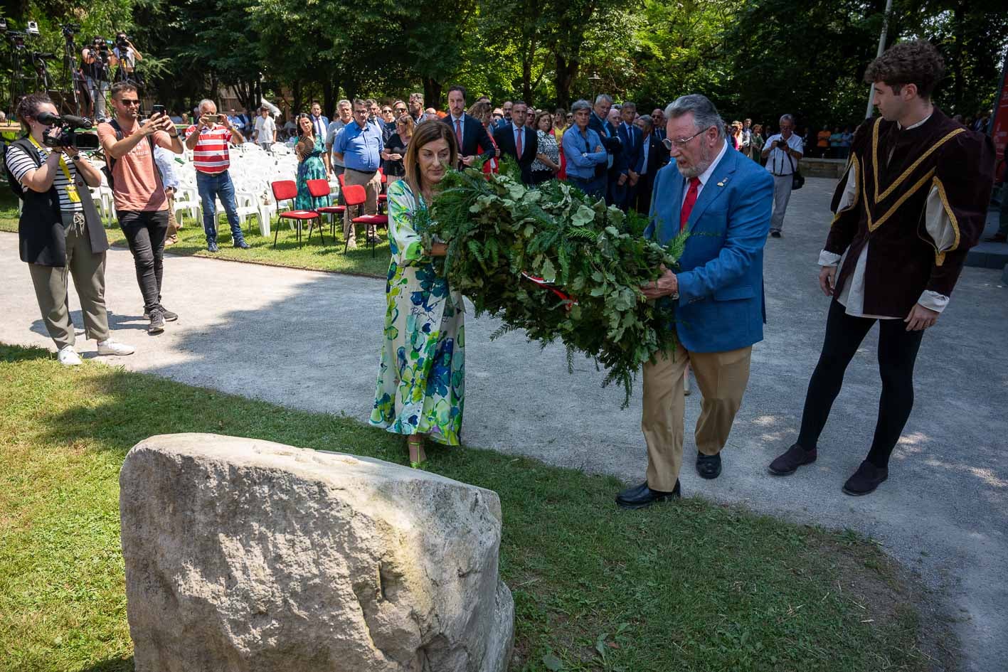 La presidenta Buruaga y el merino mayor han depositado una corona de tejo y roble, símbolo de la unión entre la Cantabria antigua y la moderna, ante el monolito levantado junto a la Casa de Juntas «en recuerdo a los que persiguieron la unidad de los valles y jurisdicciones cántabras»