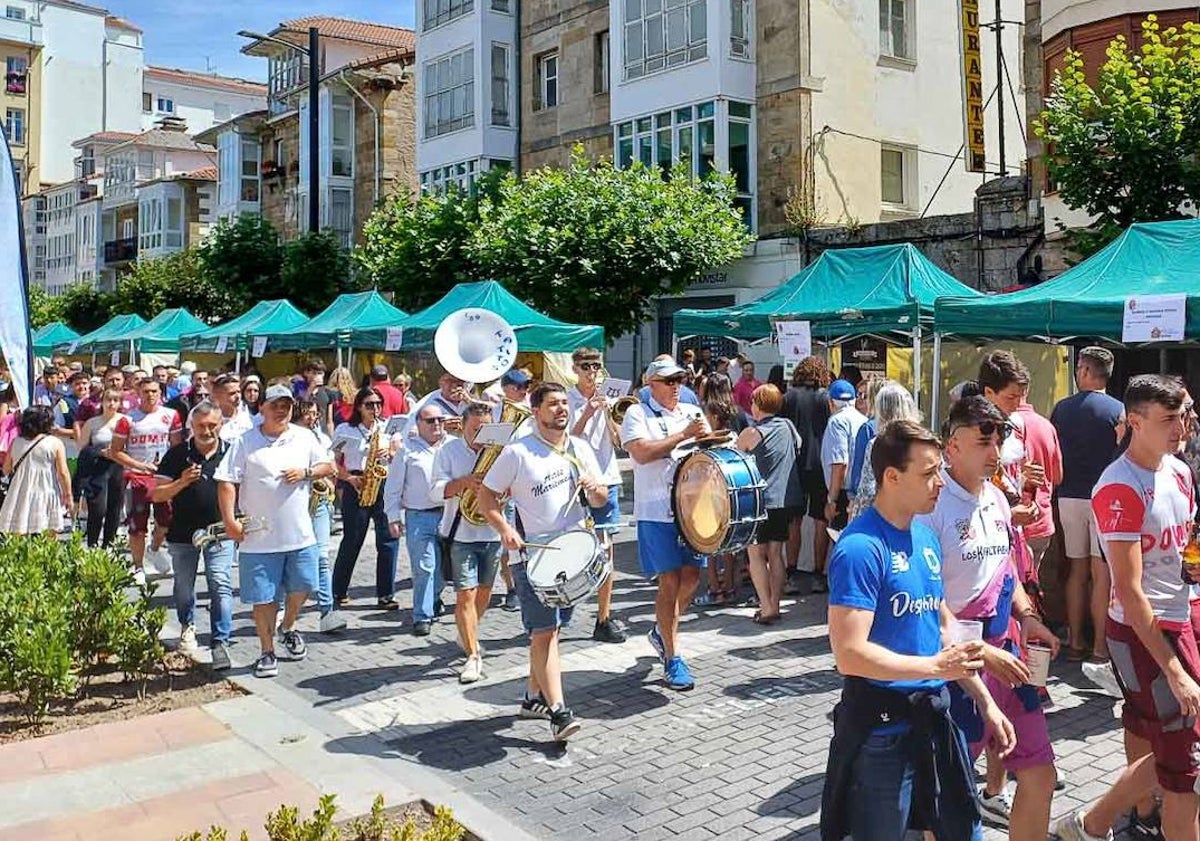 Imagen principal - Los peñistas de San Mateo, charanga y visitantes en el mercado instalado en Reinosa.