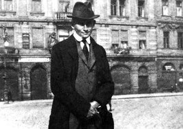 El escritor checo Frank Kafka posa ante el Kinsky Palace en la plaza de Praga.