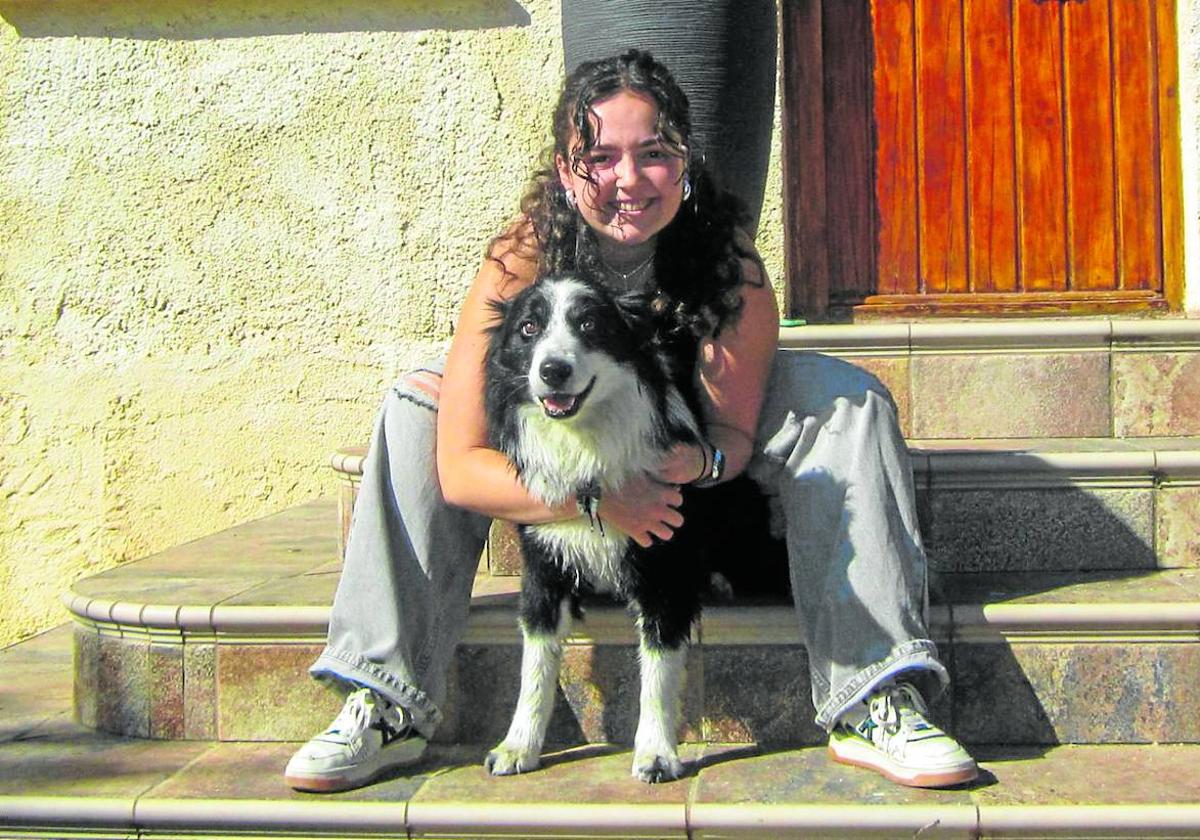 Noemí Borrallo posa con su mascota Teddy, un border collie, en la puerta de casa.