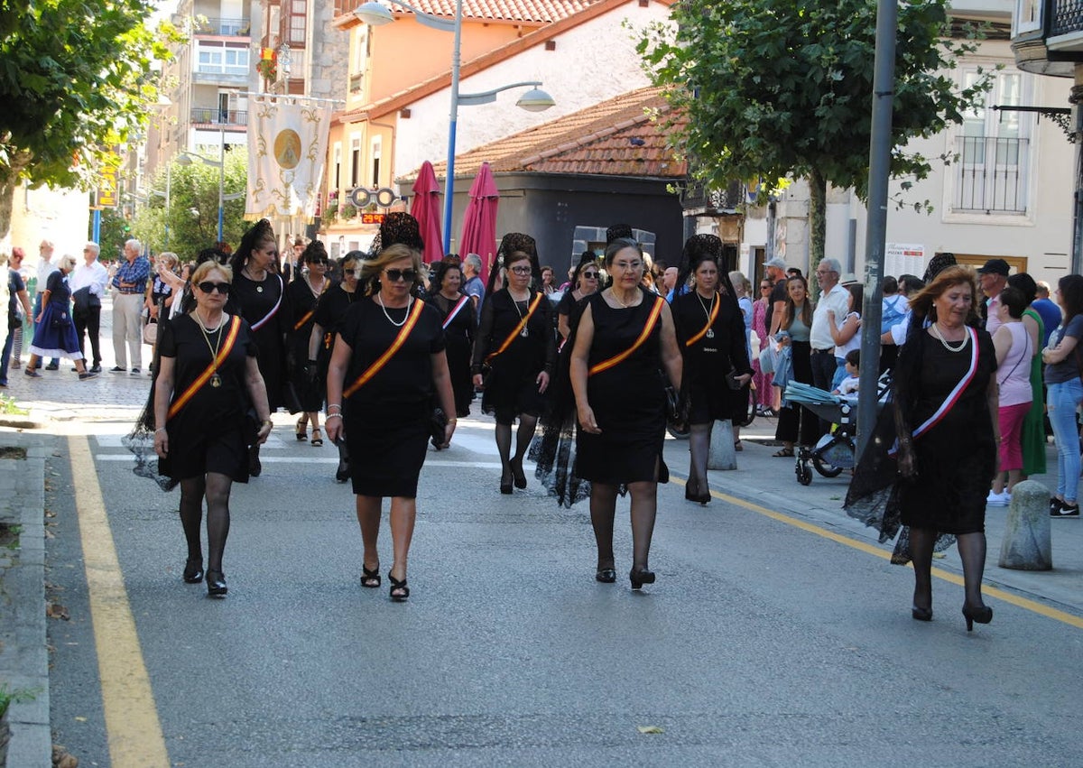 Imagen secundaria 1 - Las Marchosas sacando a hombros a la Morenuca de la iglesia (foto principal). Vecinas ataviadas de Manolas abriendo la procesión y la charanga de Los Ronceros tocó durante todo el recorrido. 