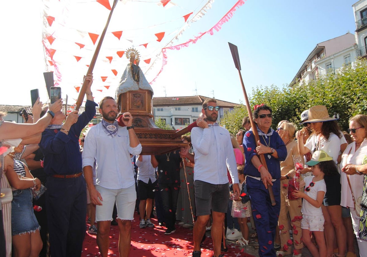 Integrantes de la murga Artistas llevan a hombros a la Virgen del Puerto.