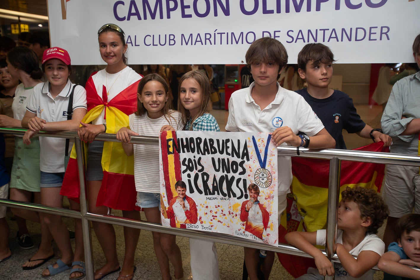 Diego y Florian con la pancarta , 'Enhorabuena. Sois unos cracks', adornadas con sus fotos en el podio olímpico