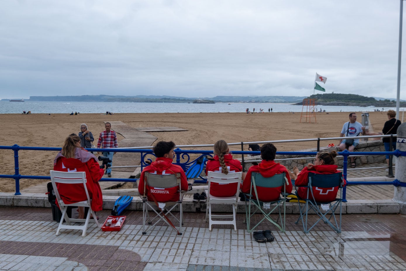 Los socorristas, con cazadoras, observan la playa de El Sardinero, vacía por el mal tiempo