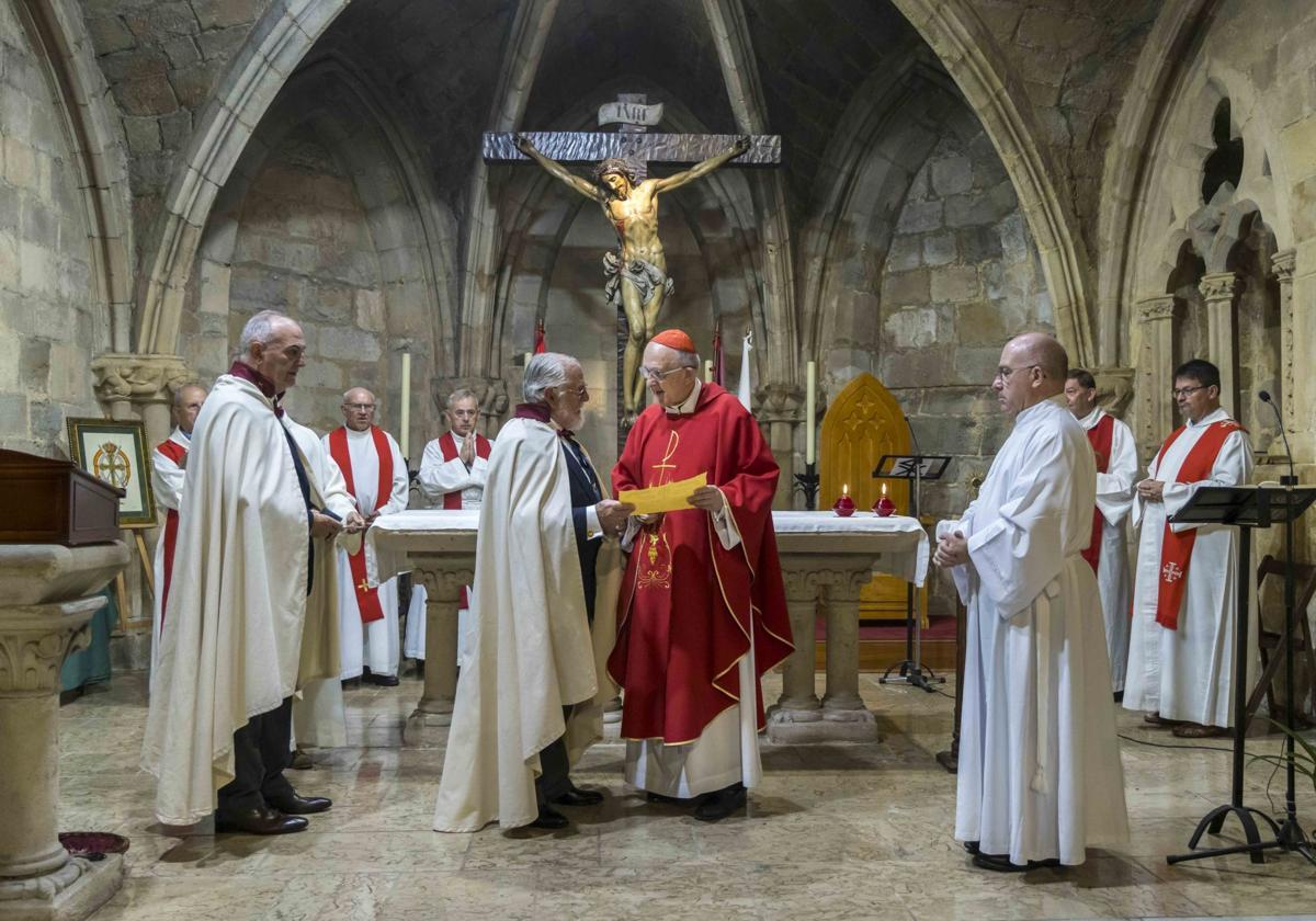 El Hermano Mayor de la Hermandad, José María Mazarrasa, muestra al cardenal Carlos Osoro el título acreditativo de su distinción.