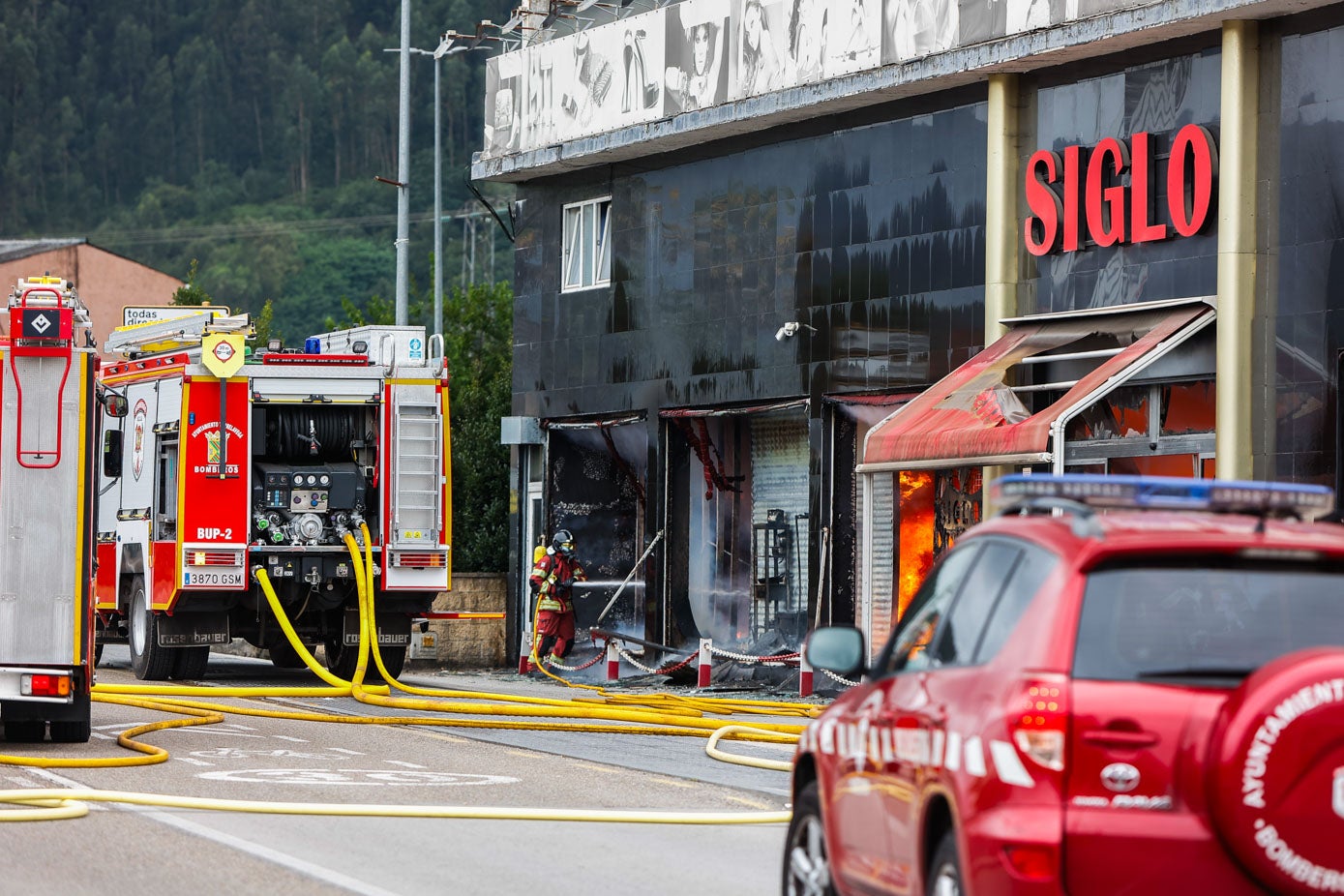 Los bomberos enfrían la fachada totalmente calcinada