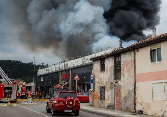 Los Bomberos trabajan en las inmediaciones del bazar Siglo, del que sale una enorme cantidad de humo.