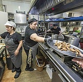 El equipo de cocina trabaja a pleno rendimiento para sacar todos los pedidos durante el servicio.