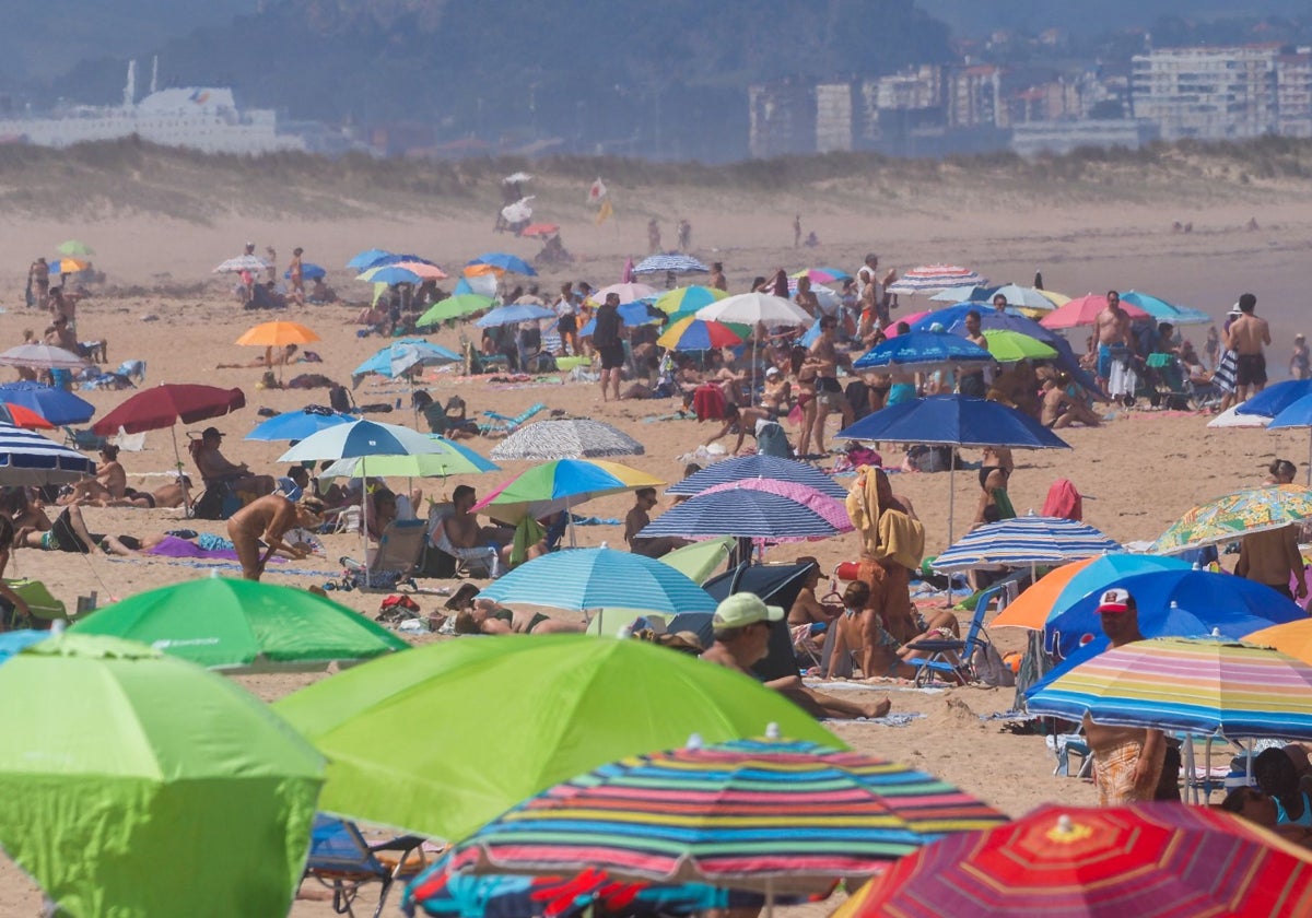 La playa de Somo se llenó de bañistas este domingo para sobrellevar la jornada calurosa.