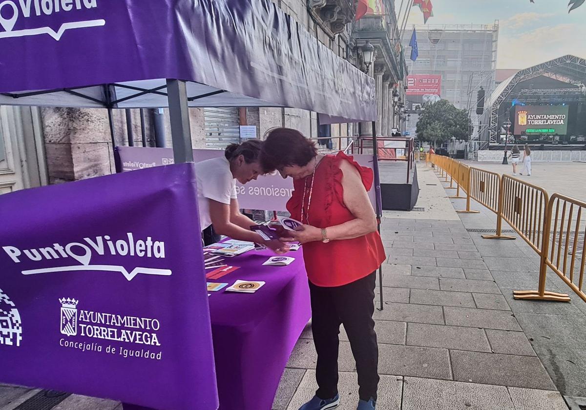 Toñi Herrera, vecina de Torrelavega, consulta unos folletos en el Punto Violeta del Bulevar Demetrio Herrero junto a una de sus responsables, Gianina Cristina Dracinschi.