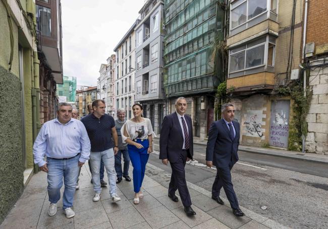 Igual y Media, junto a otros miembros del Ayuntamiento, del Gobierno y de la asociación de vecinos, junto a los edificios que se derribarán.