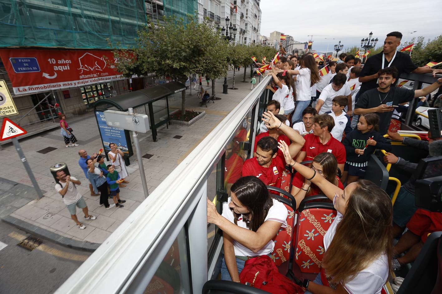 Los deportistas y técnicos saludan desde el autobús que recorrió la ciudad desde el Palacio de los Deportes hasta el Ayuntamiento