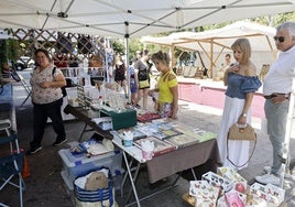 Los ciudadanos observan el contenido de uno de los puestos del Mercado Artesano en Pequeñeces.