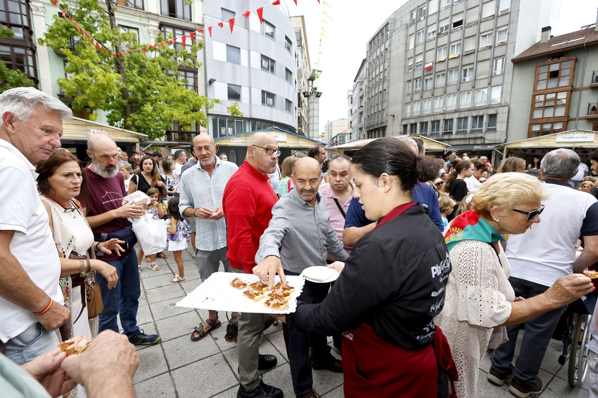 Asistentes a la feria de este viernes prueban unos dulces, en la Plaza Mayor. 