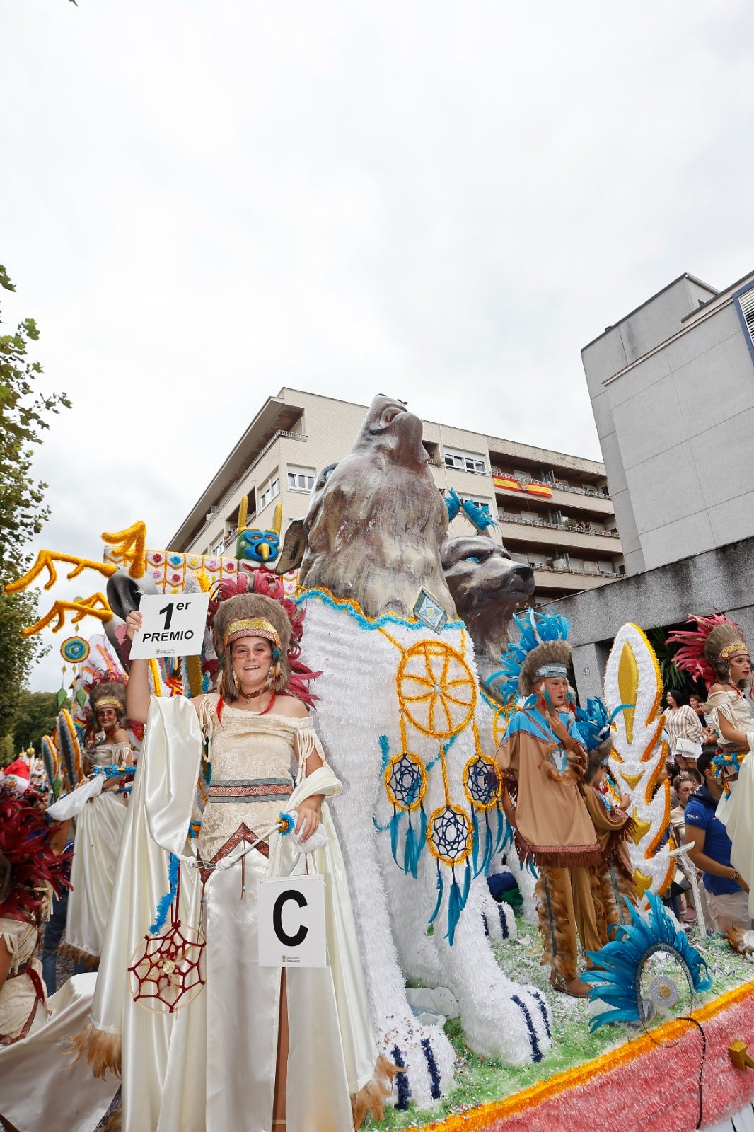 Una de las integrantes de Mandala exhibe el cartel de carroza ganadora. 