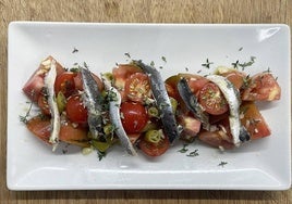 Ensalada de tomates y anchoas marinadas.