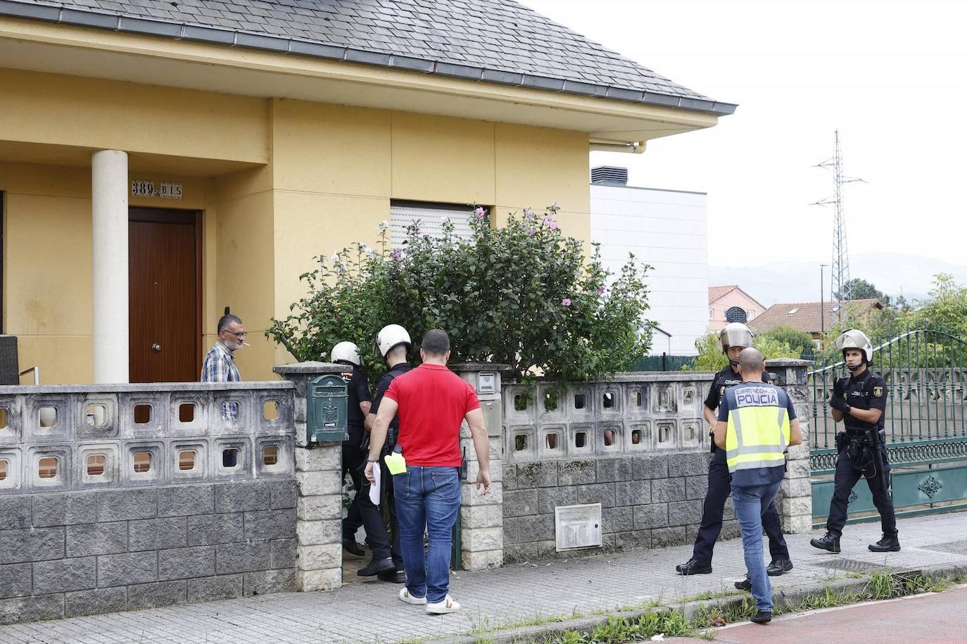 Varios agentes acceden a la casa con ayuda del propietario.