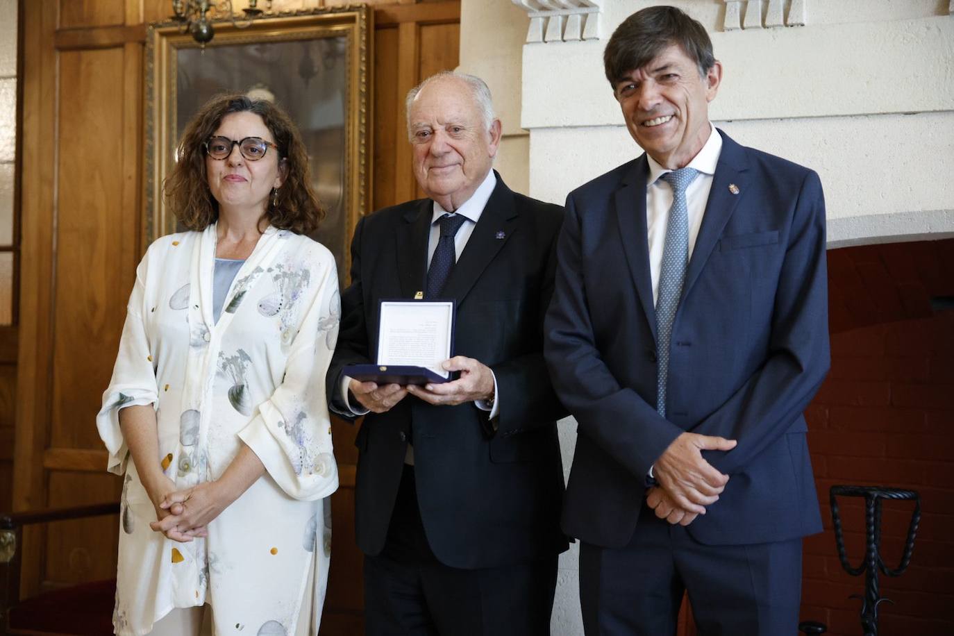 Gaspar Roberto Laredo, presidente de la Fundación Caja Cantabria, muestra la medalla de la UIMP acompañado por Matilde Carlón y Carlos Andradas.