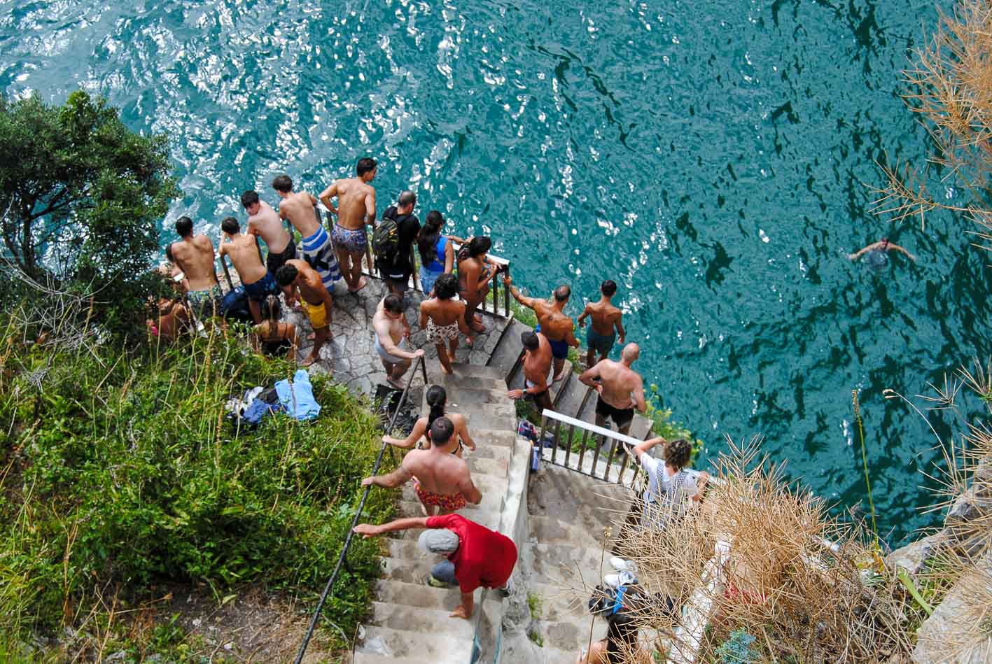 Algunos visitantes aprovechan para tirarse al agua desde los últimos escalones.