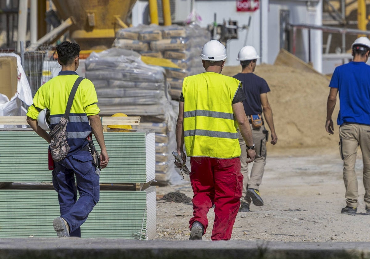 Cuatro hombres trabajan en una obra con los equipos de protección.