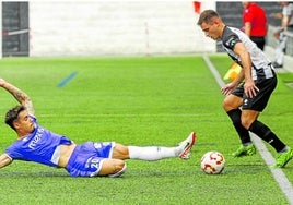 Edu Fontán,d el Escobedo, trata de mantener el balón mientras un rival del Salamanca intenta robárselo.